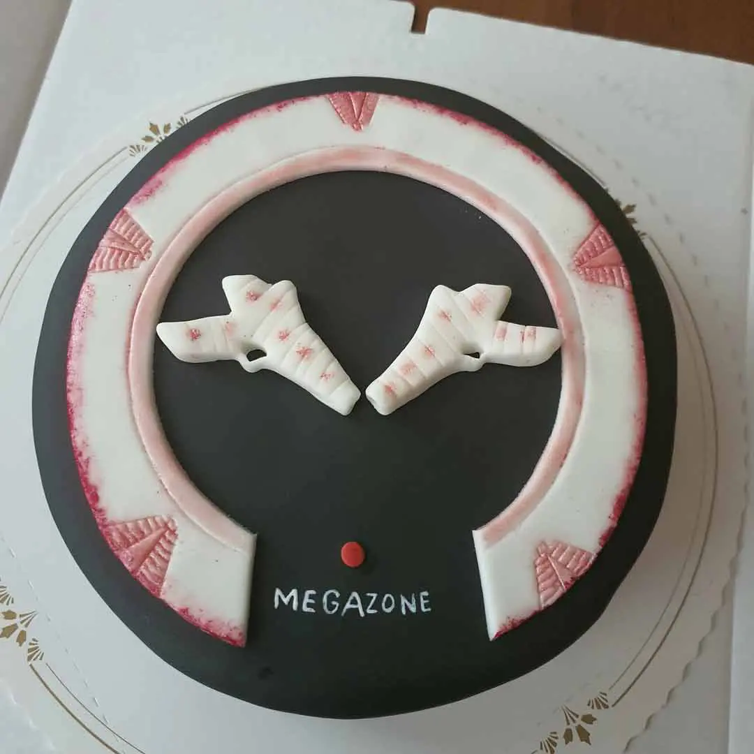 Megazone-teemainen kakku, jonka päällä on megazone-asekoristeet