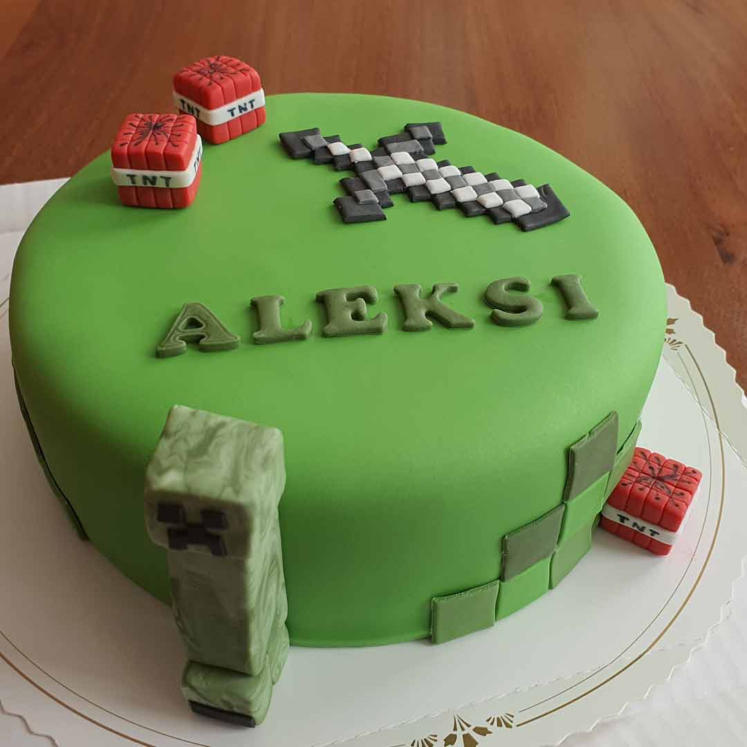 Vihreä kakku, joka on koristeltu Minecraft-hahmoilla ja esineillä